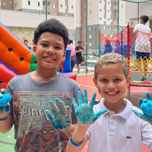 Amigos sorrindo com as mãos pintadas de azul