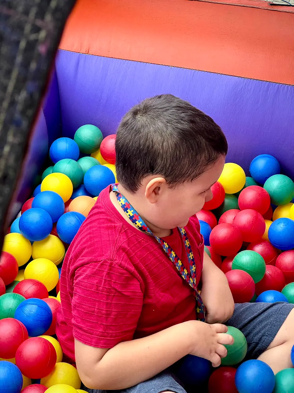 Menino brincando na piscina de bolinhas inflável